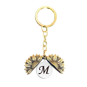 Détail du porte-clés médaillon tournesol avec lettre M cursive personnalisée gravée