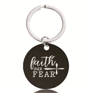 Detail of round black pendant keychain with faith OVER FEAR engraving and cross icon