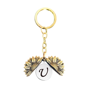 Détail du porte-clés médaillon tournesol montrant le pendentif lettre V interne