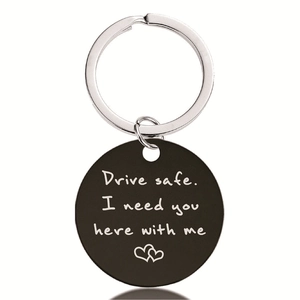Macro detail of black stainless steel keychain with Drive Safe engraved text and hearts