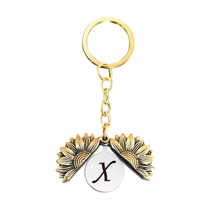 Détail du porte-clés tournesol avec la lettre X gravée à l'intérieur du pendentif doré