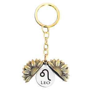 Detail of golden sunflower locket keychain with Leo zodiac sign engraving inside