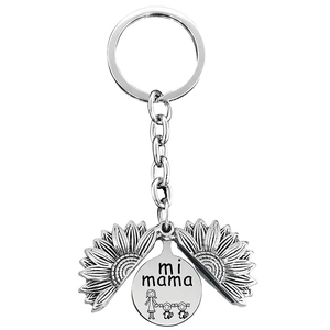 Macro view of silver sunflower locket keychain with mi mama engraving and family drawing