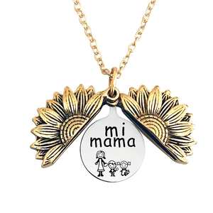 Detail of opening sunflower locket necklace with mi mama text and mother child engraving