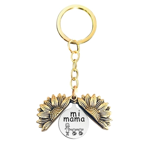 Close-up of engraved sunflower locket keychain with mi mama text and mother daughter illustration