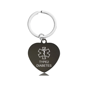 Macro shot of black heart-shaped medical alert keychain with Type 2 Diabetes engraving