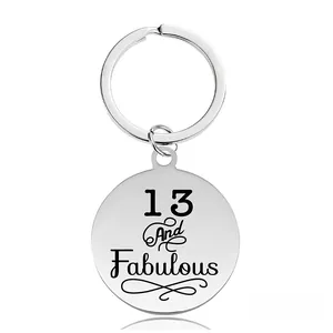 Gros plan d'un porte-clés rond en acier inoxydable poli gravé 13 And Fabulous