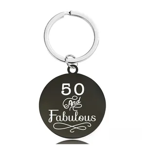 Détail d'un porte-clés rond noir gravé 50 and Fabulous pour cadeau d'anniversaire spécial