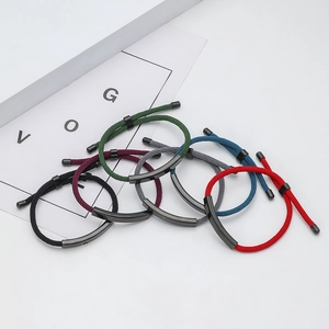 Macro detail of multicolored braided cord bracelets with curved stainless steel metal tubes