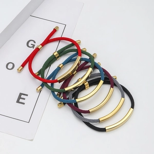 Detailed view of woven bracelets with curved gold metal tubes in multiple colors