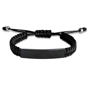 Macro detail of adjustable black braided rope bracelet with a custom engravable metal ID tag