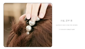 Détail d'une pince à cheveux élégante avec de grandes perles sur cheveux bruns