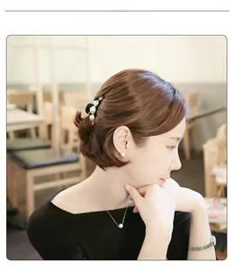 Femme élégante portant une pince à cheveux noire avec perles et collier assorti au café
