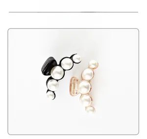 Détail de deux élégantes pinces à cheveux à perles en noir et champagne transparent