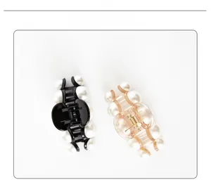 Détail de deux pinces à cheveux en acrylique minimalistes avec perles en noir et champagne
