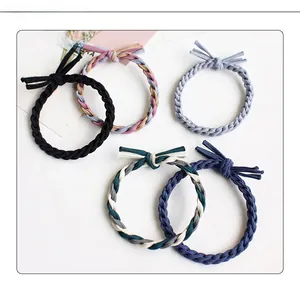 Dettaglio di cinque elastici intrecciati per capelli con fiocchi eleganti in blu e nero