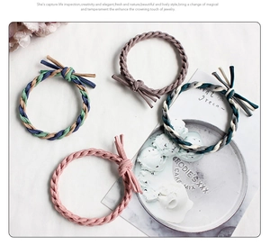 Dettaglio di quattro elastici per capelli intrecciati con nodi a frange in colori pastello