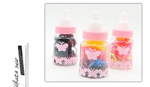 Detail eines Behälters in Babyflaschenform mit bunten Haargummis für Mädchen