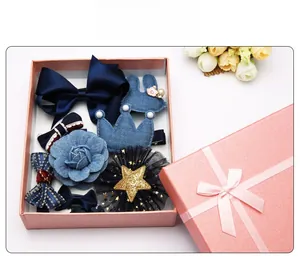 Détail d'un ensemble d'accessoires de cheveux bleus pour enfants dans une boîte cadeau rose
