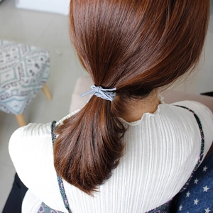 Vista posteriore di una modella con elastico per capelli intrecciato grigio spesso per coda