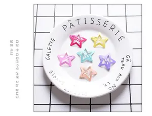Close-up of star-shaped snap hair clips in matte macaron colors on a white ceramic plate