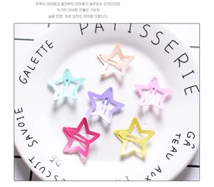 Close-up of star-shaped metal hair clips in 6 matte candy colors on a decorative plate
