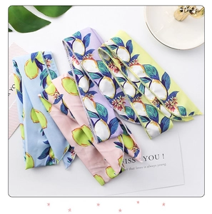 Detail of four colorful scarves featuring lemon patterns and delicate edge stitching