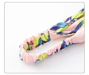 Detail view of pink floral hairband featuring elastic pleated back for comfort and fit