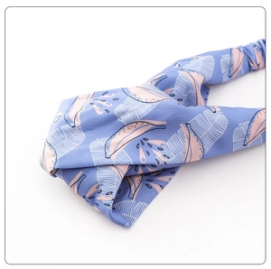 Close-up of tropical banana leaf and pink fruit print on light blue fabric headband