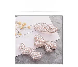 Detailed view of three elegant pearl hair clips with rhinestone accents on gold alloy base