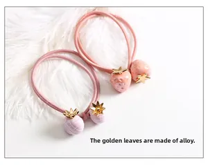 Détail d'élastiques à cheveux mignons avec fraise et ananas et accents de feuilles dorées