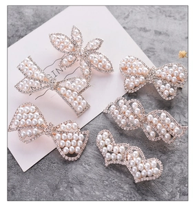 Detailed view of six silver hair clips with sparkling rhinestones and white pearls