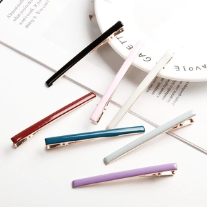Set mit 7 bunten minimalistischen Emaille-Haarspangen auf weißem Teller und Magazin