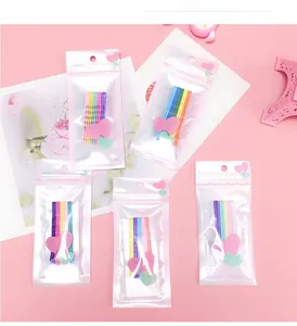 Détail de pinces à cheveux ondulées colorées dans un emballage rose à motif de cœur