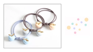 Détail d'élastiques à cheveux avec pendentifs pommes aux couleurs macaron et feuilles dorées