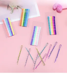 Détail de barrettes à cheveux pastel aux formes ondulées et droites sur fond rose doux