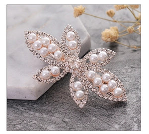 Close-up of elegant flower hair clip with sparkling rhinestones and white pearls