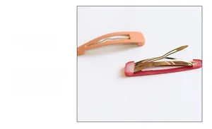Detail of matte hair clips in light orange and pink with metal base and Korean style