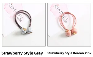 Gros plan de pendentifs fraises sur élastiques à cheveux gris et roses avec étoiles dorées