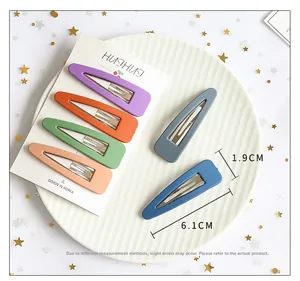 Set of six matte water-drop hair clips in vibrant colors displayed on a white plate