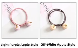 Détail de breloques en forme de pomme lavande et taupe sur des élastiques à cheveux