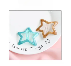 Détail de barrettes en forme d'étoile avec paillettes en bleu menthe et doré