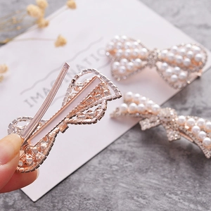Elegant bow hair clips set featuring pearls and rhinestones on gold metallic base