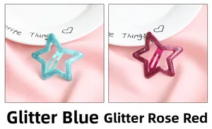 Gros plan de pinces à cheveux étoiles à paillettes rose et bleu sur un fond de satin