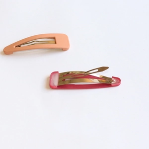 Minimalist matte pink and translucent rose red snap hair clips on a white background