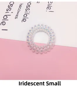 Detail eines kleinen irisierenden weißen Spiralhaargummis mit Perlglanz auf Diagonalhintergrund