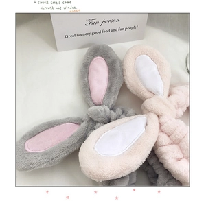 Close-up of soft coral fleece rabbit ear headbands in light grey and pink pastel tones