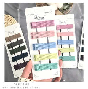 Detail shot of colorful bobby pin sets on white cards with aesthetic pearls and lace background