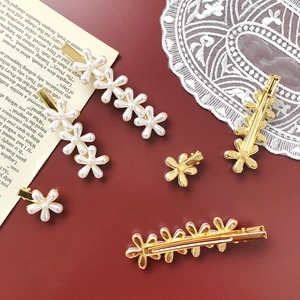 Detail shot of vintage pearl flower hair clips on an elegant lace and red background