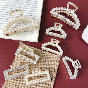 Detail of luxury pearl and rhinestone hair claws in various shapes on a red background